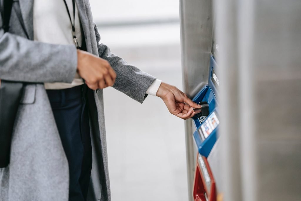 Image of Faceless woman buying metro ticket via electronic machine