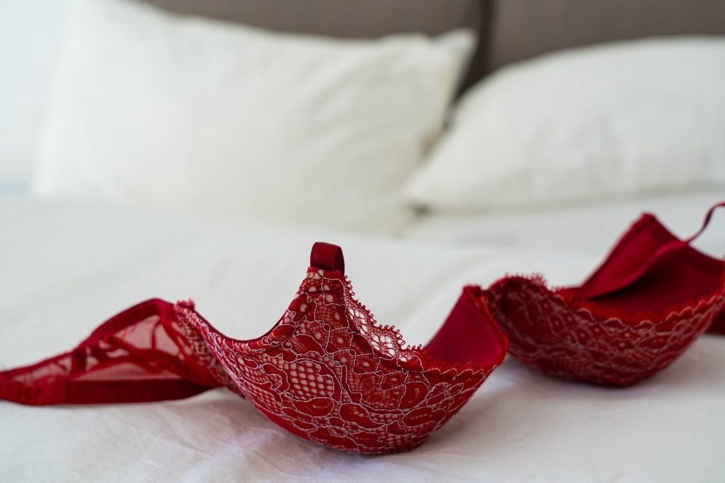 Image of Red Lace Brassiere on White Bed