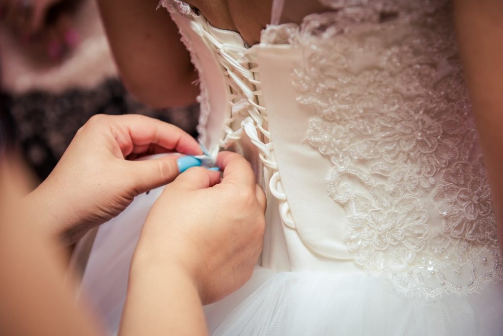 Image of Photo of Woman Fixing the Wedding Gown