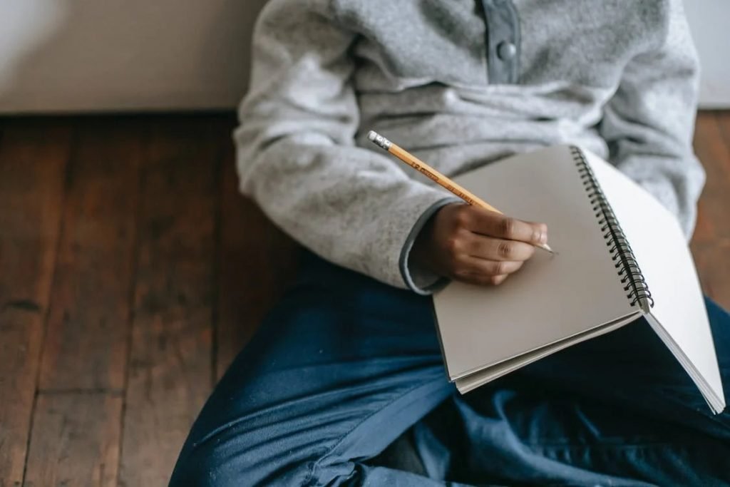 Image of Crop black kid with notepad