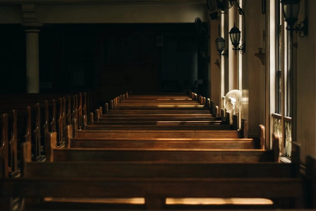 Image of Brown Wooden Church Bench Near White Painted Wall