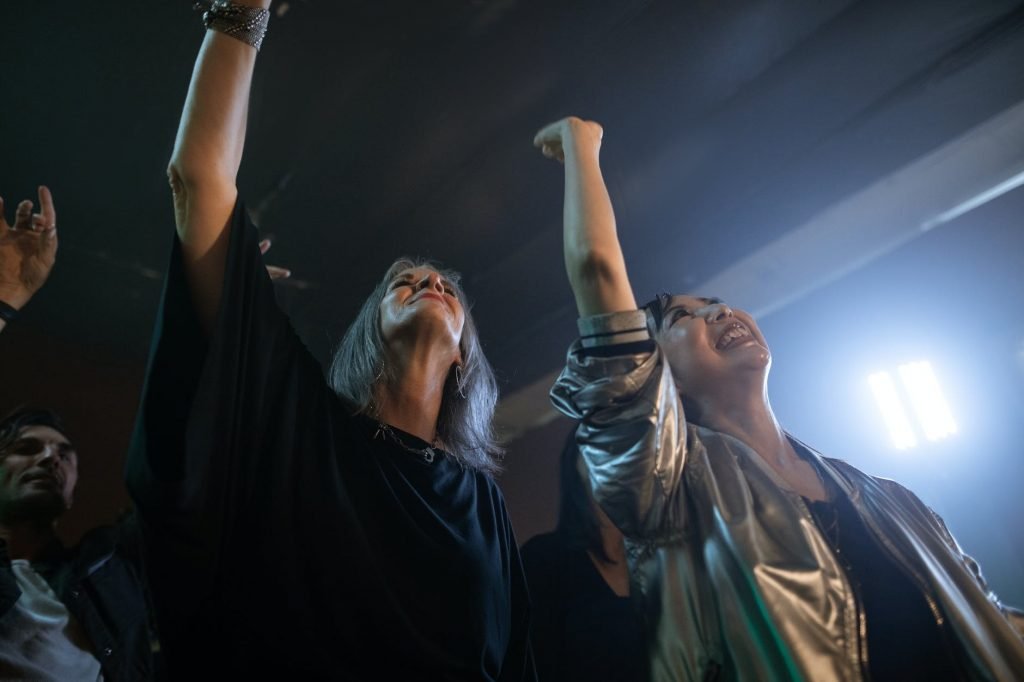 Image of Woman in Black Dress Raising Her Hand