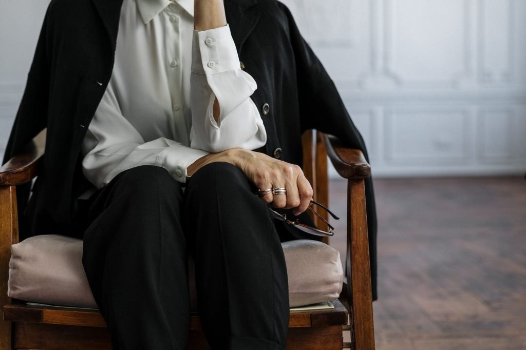 Image of Man in Black Suit Sitting on Brown Wooden Armchair