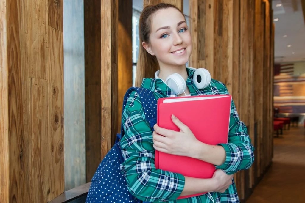 Image of Woman Standing in Hallway While Holding Book