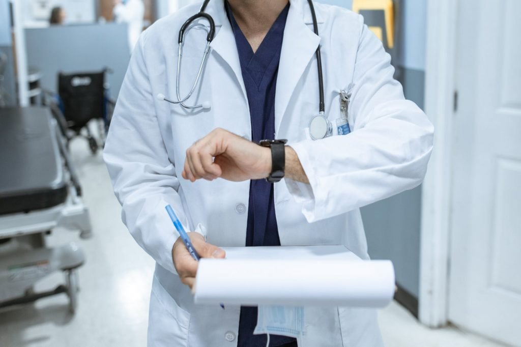 Image of Person in White Coat Holding Blue Pen
