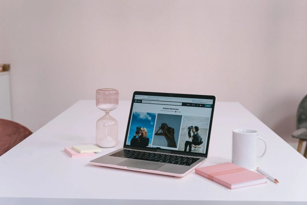 Image of A Laptop Near the Hourglass on the Table