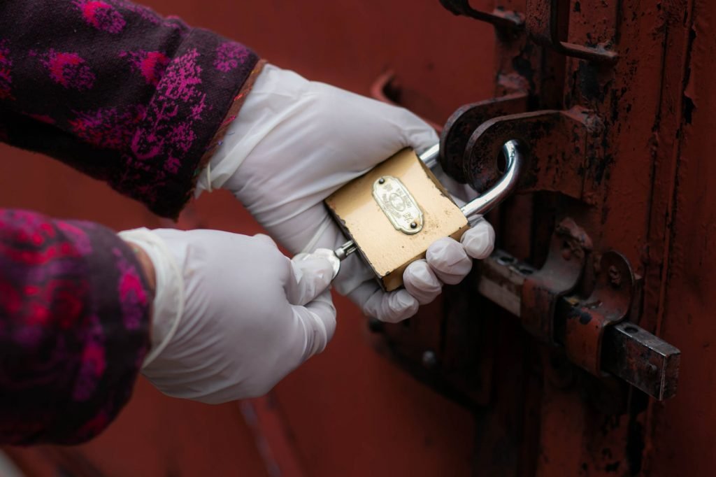 Image of Person Holding Gold Padlock With Key