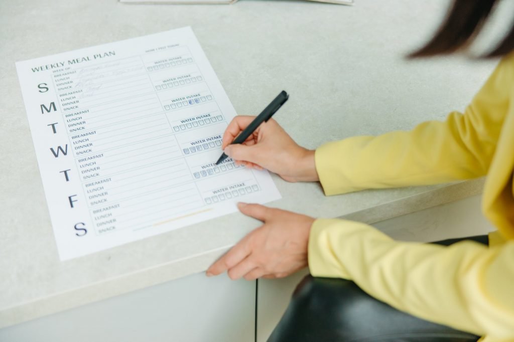 Image of Person Holding Black Pen Writing on White Paper