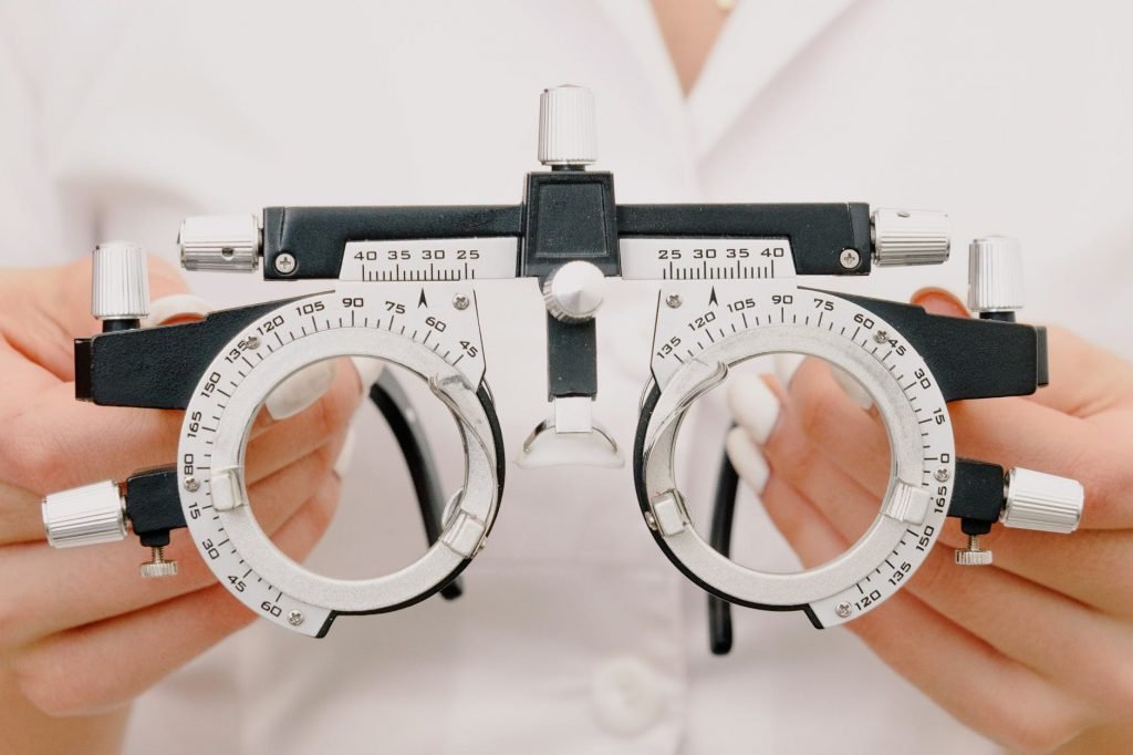 Image of Crop unrecognizable female optometrist with trial frame in hands