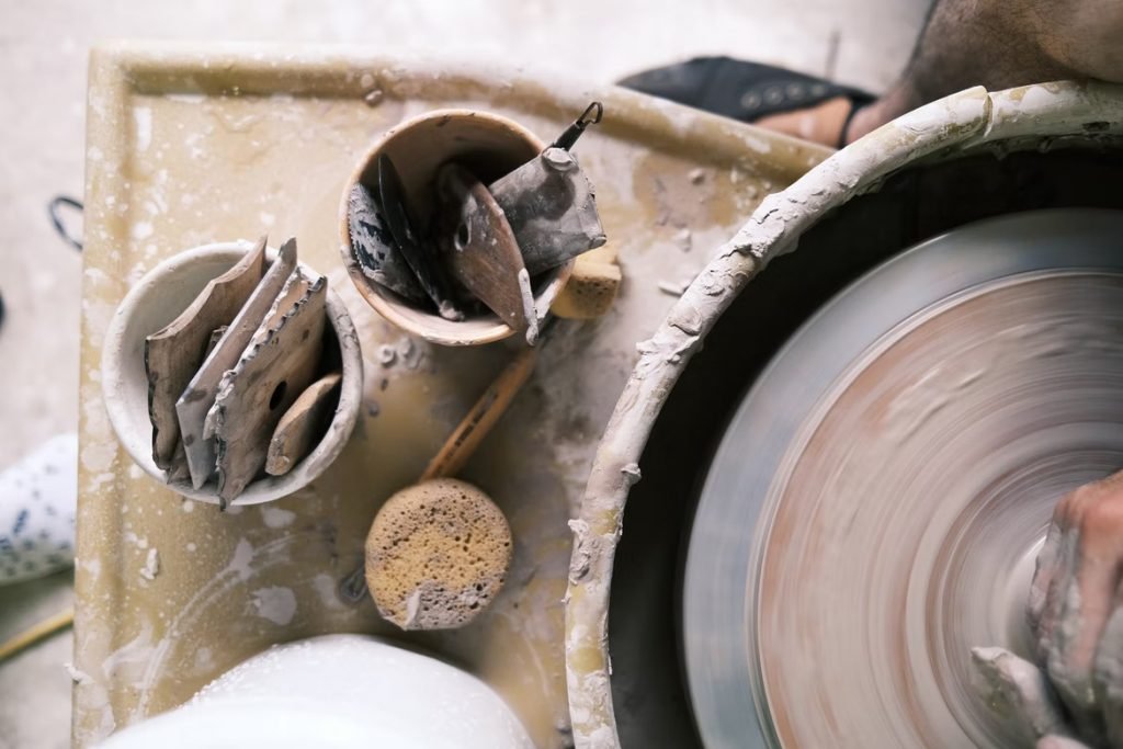 Image of Working with stoneware clay on a Brent wheel.