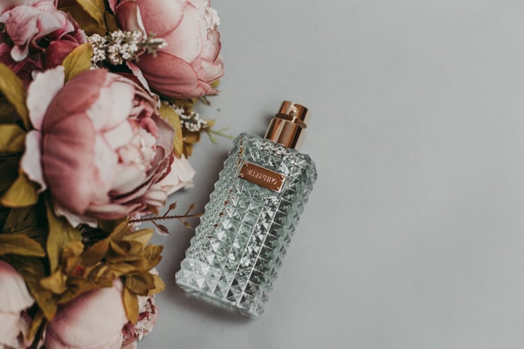 Image of Photo Of Perfume Bottle Beside Artificial Flowers