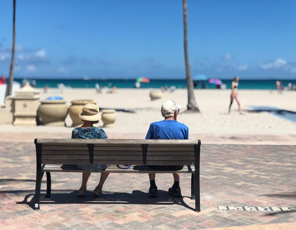 Image of Man and Woman Sitting on Brown Wooden Bench