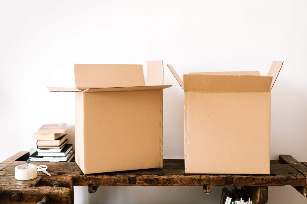 Image of Carton boxes and stacked books on table