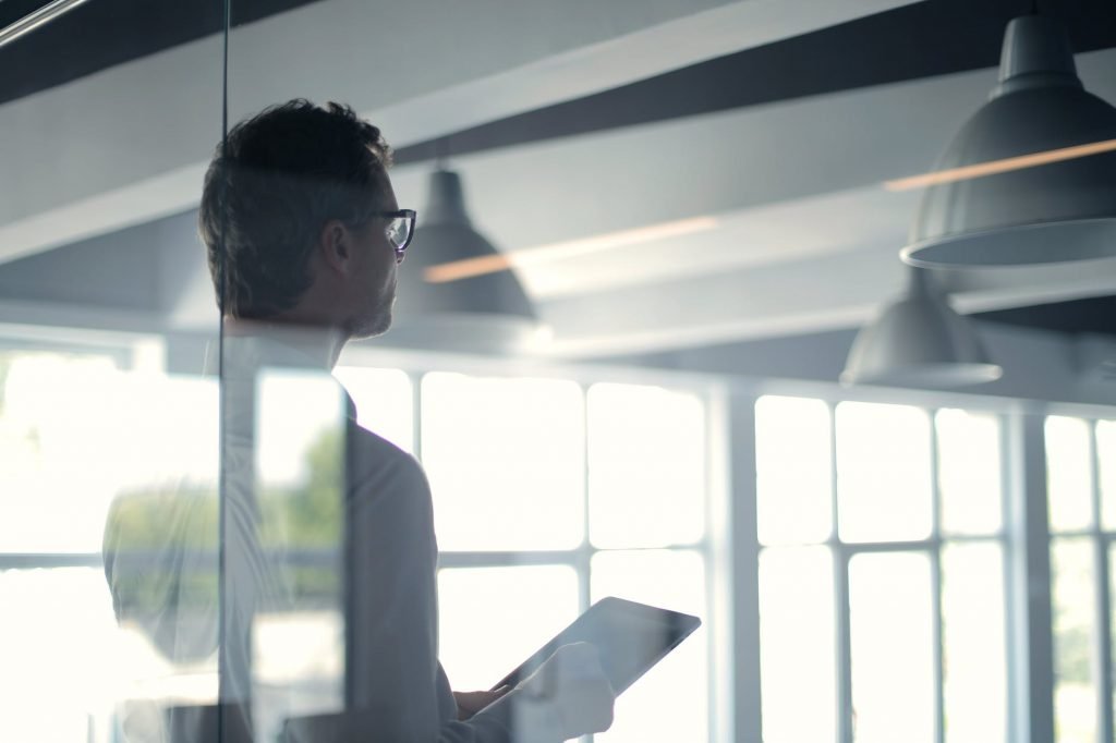 Image of Formal man with tablet giving presentation in office