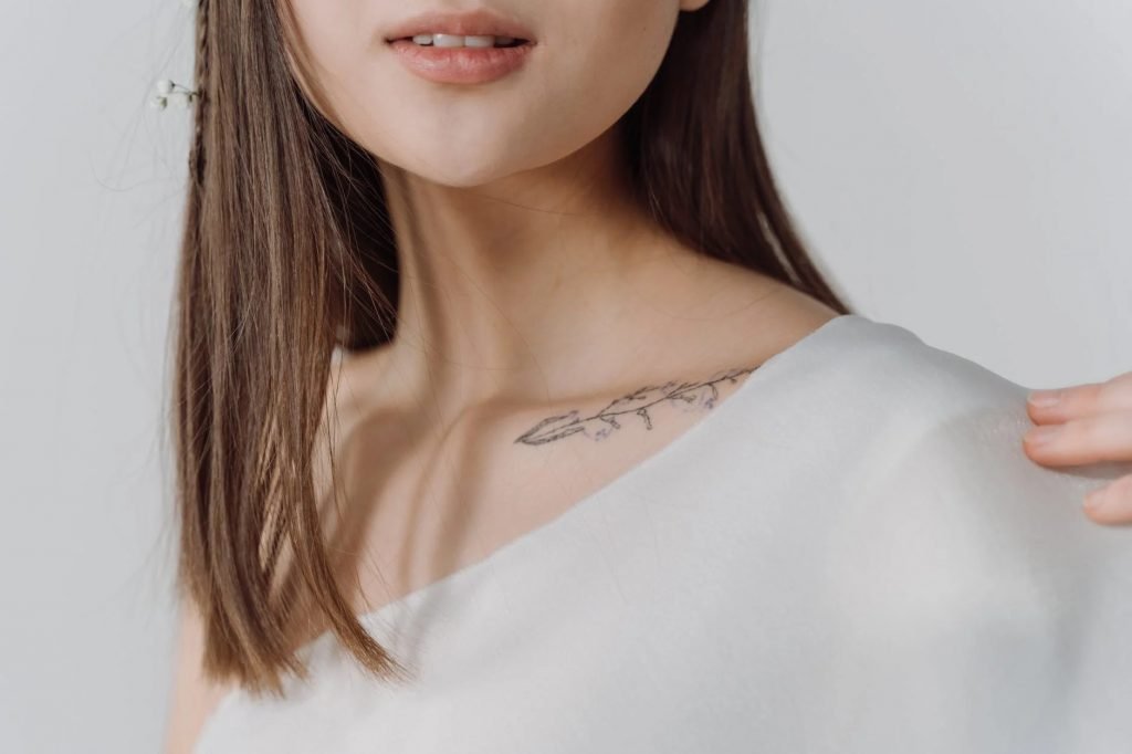 Image of Young Woman Wearing White Top with Tattoo
