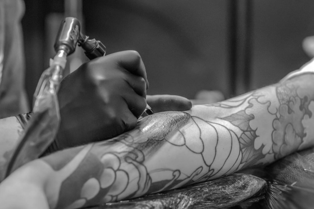 Image of Grayscale Photo of Person Applying Tattoo
