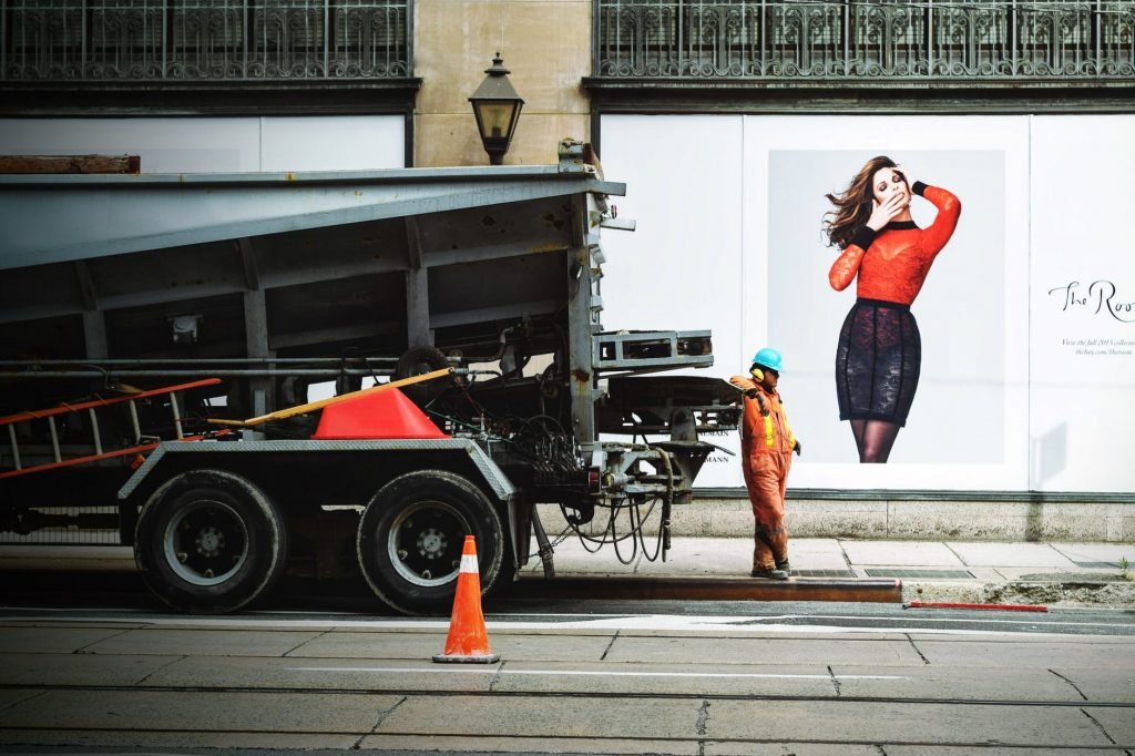 Image of Man in Orange Safety Suit Standing Beside Truck Bed
