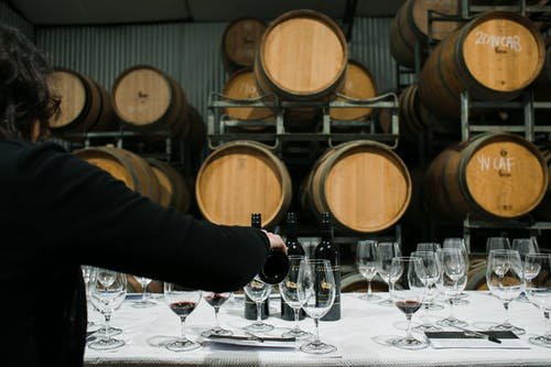 Image of Crop person pouring wine in winery