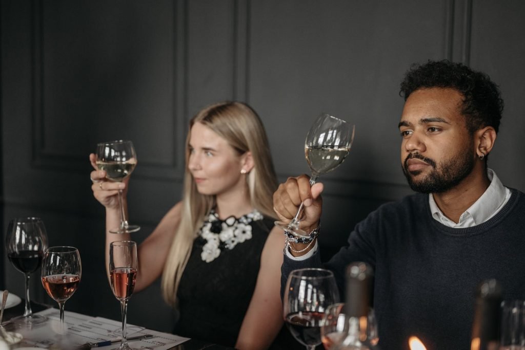 Image of A Man and a Woman Sitting at the Table Holding Wine Glasses