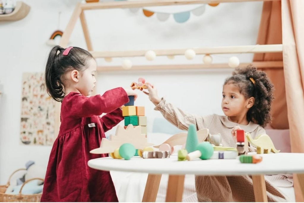 Image of Girl In Red Dress Playing A wooden Blocks